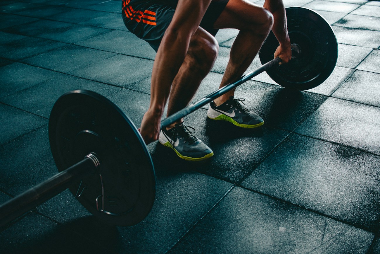 An athlete preparing for a barbell lift in a gym